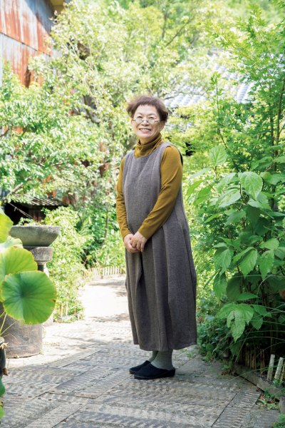 「他郷阿部家」の庭にて。10年以上かけて、江戸時代に銀山の役人だった阿部清兵衛の屋敷を修復。現在は宿泊施設として、1日3組限定で受け入れる。登美さんは昼間は「群言堂」のデザイナーを務め、夜は阿部家で宿泊客をもてなす。