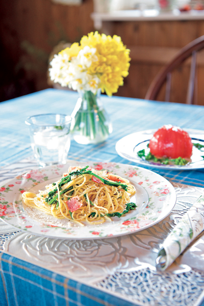畑でとれたトマトが丸ごと楽しめるお手製のサラダや、菜の花のパスタ。くつろいでほしいと、お皿やキッチンマットなどにもこだわっているそう。