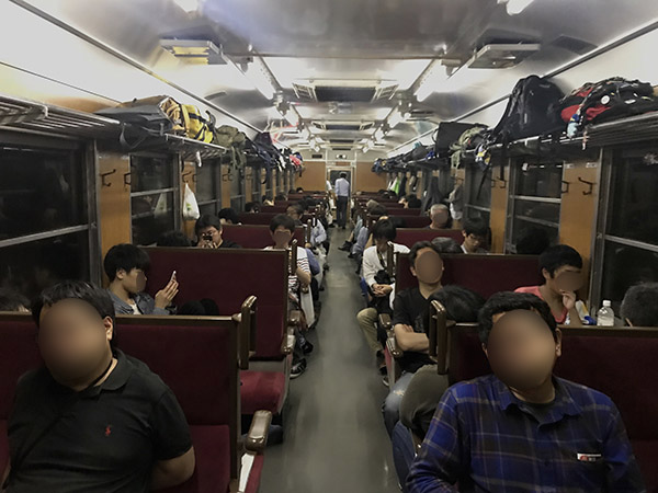 減光された車内で寝る乗客たち