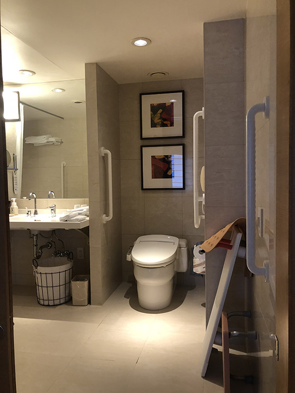 ユニバーサルルームのバス、トイレの例。段差がなく、洗面台の足元の空間が広い。